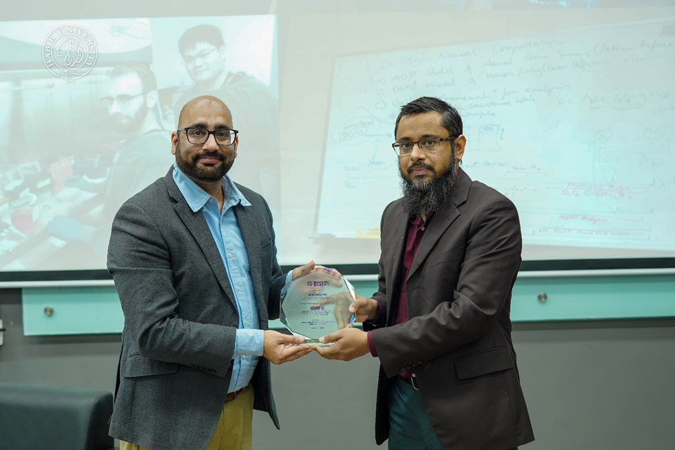 dr. muhammad farhan presenting dr. adeel razi with a memento in recognition of his contributions on neuroai