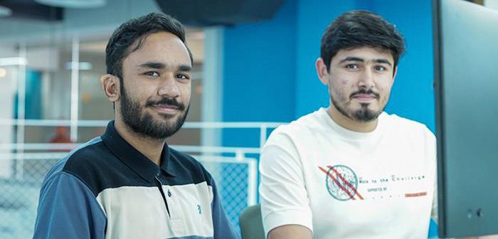 two habib cs students pose in office at liberty city ventures during analyst internship