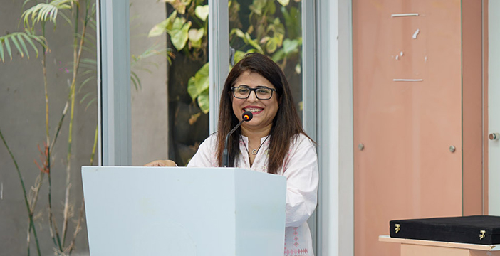 Aqsa Junejo smiles at the podium during the Habib University and National Bank of Pakistan scholarship ceremony.