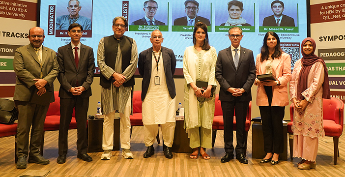 Panelists and organizers pose for a group photo on stage at the Teaching & Learning Symposium 2026 at IBA Karachi.