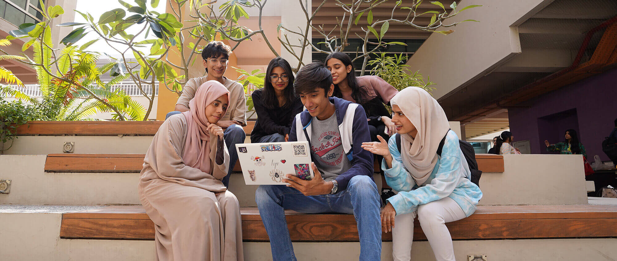 group of students looking in the laptop