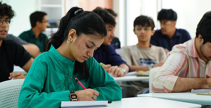 students take notes during a comparative humanities lecture in a classroom setting