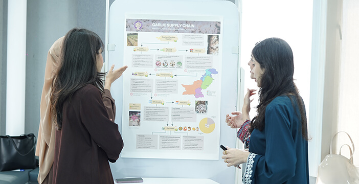Students presenting a garlic supply chain project linked to social development.